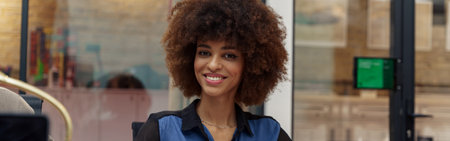 Smiling african businesswoman sitting on his workplace in modern office