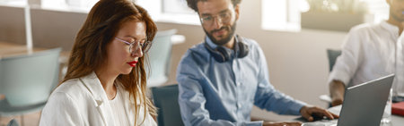 Group of young diverse coworkers analyzing sales report while working together in the office