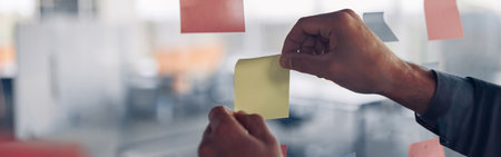 Businesswoman hands is sticking sticky notes on motivation board in officeの写真素材