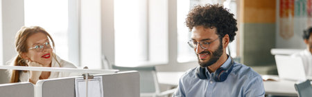 Businesspeople working together in bright office, sitting at desk