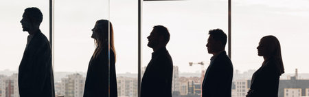 Silhouette photo of a group of businessmen standing side by side in profile in office
