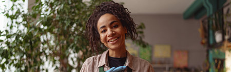 Portrait of smiling woman florist presenting beautiful floral composition with succulent plant