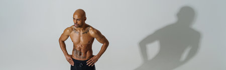 Top view of sportsman with naked torso is warming up on white studio background before workoutの写真素材