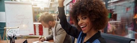 Happy african businesswoman sitting on his workplace in modern office on colleague backgroundの写真素材