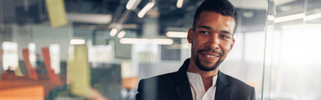 Businessman showing on sticky notes on glass wall while working in modern officeの写真素材