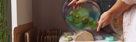 Female decorator hands place handmade epoxy resin tray on stand expositionの写真素材