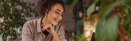 Successful female florist working laptop in own floral studio, check customers orderの写真素材