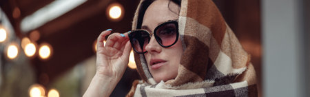 Portrait of beautiful young lady in sunglasses with scarf covering head. Stylish woman.の写真素材