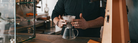 Men barista making a drip filter coffee standing by counter in coffeeshopの写真素材