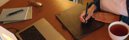 Cropped image of a graphic designer using digital tablet in his work at home office