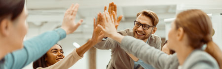 Young team putting hands up for new startup in the officeの写真素材