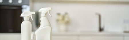 Cleaning set. Detergent bottles, stack of rugs and protective rubber gloves on surface in the...
