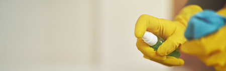 Close up shot of cleaning lady in rubber gloves using antibacterial sanitizer spray and cloth while disinfecting the screen of digital tablet pcの写真素材