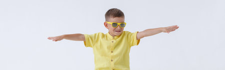 Adorable little boy sitting on yellow travel bagの写真素材