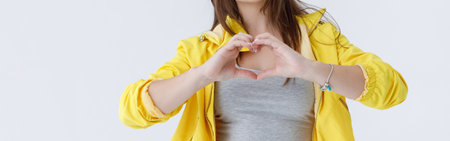 Beautiful young woman in headphone showing heart signの写真素材