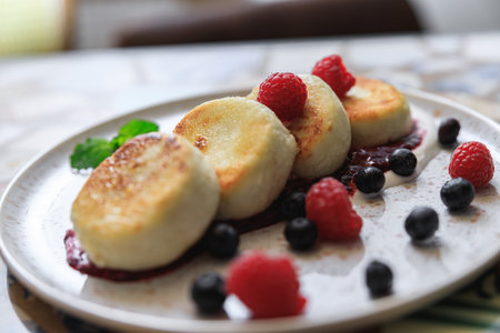 Cheesecakes served on plate with berries, cream and sugar powder ready for eating in restaurantの写真素材