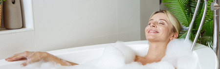 Attractive Caucasian young female enjoying bubbles, relaxing and taking bath in morning.の写真素材