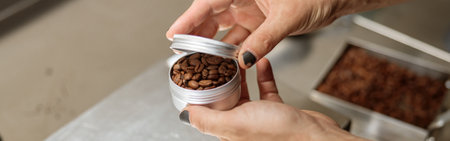 Male hands holding metal container with coffee beans