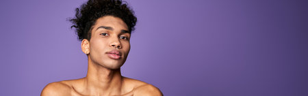 Portrait of latin american transgender model on purple background. Handsome young man posing cameraの写真素材