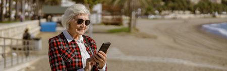 Elegant senior lady standing outdoors by seafront