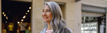 Busy mature lady taking stroll through cityの写真素材