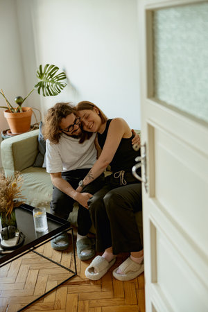 Man and woman hugging and enjoying time together in living room at home. Good relationship time