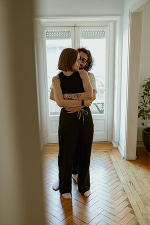 Romantic couple hugging and enjoying time together while standing at home. Good relationship timeの写真素材