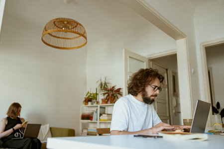 Young family couple working from home office and using laptops. Distance work conceptの写真素材