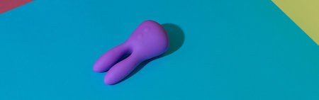 Violet dildo vibrator for clitoris on colored background with contrast shadows. Sex toy for adultの写真素材