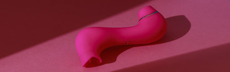 Sex toy for women also called vacuum clitoral stimulator for satisfaction on pink backgroundの写真素材