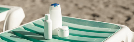 Suntan product bottles on the summer beach. Sunscreen on deck chair outdoors at beach resortの写真素材