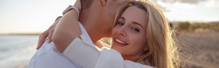 Close-up of beautiful woman hugging man on the beach