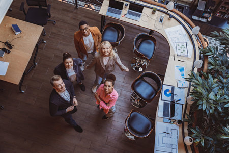 Group of coworkers standing at office and looking up at camera. Workplace and cooperation conceptの写真素材