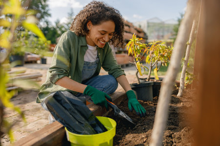 Professional woman garden worker transplants plants and takes care of flowerpots in botanic shopの写真素材