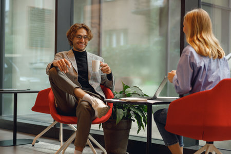 Two diverse business colleagues working together on project sitting in modern coworkingの写真素材