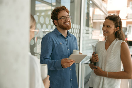 Business colleagues talking and laughing during break time in office backgroundの写真素材