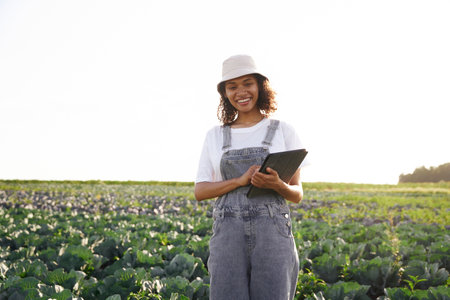 Professional woman agronomist with digital tablet works in field. High quality photoの写真素材