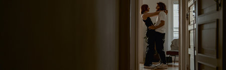 Smiling couple hugging and enjoying time together while standing at home. Good relationship timeの写真素材