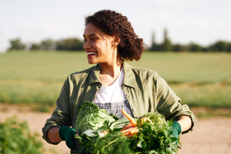 Smiling woman farmer with just harvested vegetables basket ready to sale. Agricultural conceptの写真素材