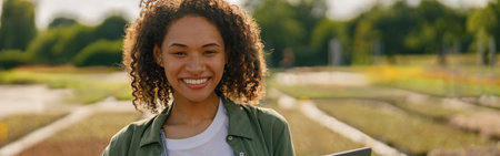 Woman gardener working on laptop while sitting on background of shop plants centerの写真素材