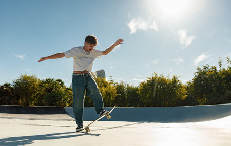 A young man doing tricks on his skateboard at the skate park. Active sport conceptの写真素材