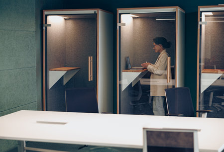 Smiling businesswoman talking with client via video call while sitting in coworkingの写真素材