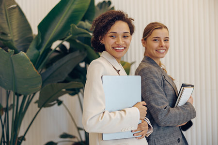 Portrait of elegant female businesswomen standing in officeの写真素材