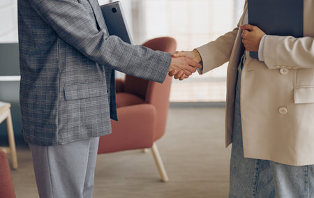 Close up of female executive manager is making successful deal with partner shaking hand at workの写真素材