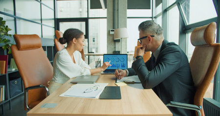 Businesswoman explains chart data during meetingの写真素材