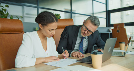 Business colleagues analyzing printed reports
