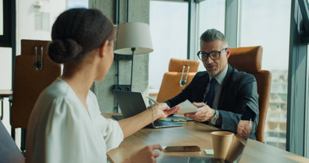 Business partners exchanging documents at meetingの写真素材