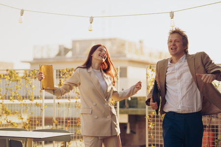 A Joyful Celebration Taking Place on a Rooftop with Friends Dressed in Business Attireの写真素材