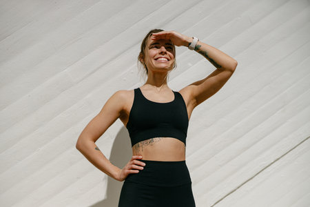 Female athlete in sportswear have a rest after morning jogging outside and looks awayの写真素材