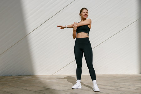 Sporty woman does warm-up exercises in morning before running training outside. Healthy fitnessの写真素材